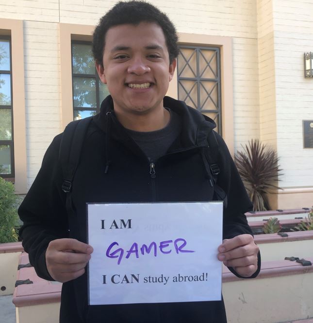 Student with I can Study Abroad sign
